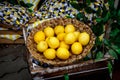 Lemons in a basket, green floral background. Royalty Free Stock Photo