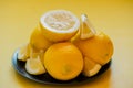 Lemons on a black plate on a yellow background. vitamin, organic