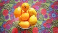 Lemons in a bowl. Textile background of floral and vegetable motifs.