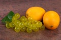 Lemons and a bunch of grapes on granite background Royalty Free Stock Photo