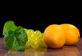 Lemons and a bunch of grapes on granite surface and black background Royalty Free Stock Photo