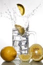 Lemons falling into a glass of ice water with splashes against isolated on white background. Refreshing Beverage Royalty Free Stock Photo