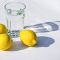 Lemons, fresh green mint and a glass glass with water on a white background. Shadows on a white background