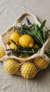Lemons and Herbs in a Mesh Bag on Beige Fabric Royalty Free Stock Photo