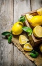 Lemons with leaves in a box on the fabric . Royalty Free Stock Photo