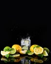 Lemons and limes against black background. Glass of lemon water and lemons on a black background. Splash. Reflection. Royalty Free Stock Photo