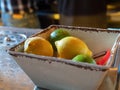 Lemons and limes with peeler sitting in bowl of a bar for bartenders to make cocktails Royalty Free Stock Photo