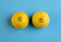 Lemons in shape of woman breast with nipple piercing on blue background Royalty Free Stock Photo