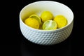 Lemons slices arranged in white cup black isolated background