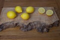 Lemons on a wooden chopping board, whole and in two halves Royalty Free Stock Photo