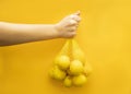Lemons on a yellow background. Close-up hand holding a bunch of lemons Royalty Free Stock Photo