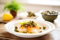 lemony cod in white dish with capers