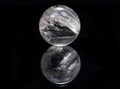 Lemurian Clear Quartz Sphere crystal magical orb isolated on a black mirror background Royalty Free Stock Photo