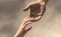 Lending a helping hand. Hands of man and woman reaching to each other, support. Solidarity, compassion, and charity Royalty Free Stock Photo