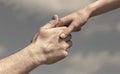 Lending a helping hand. Hands of man and woman reaching to each other, support. Solidarity, compassion, and charity Royalty Free Stock Photo