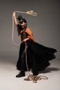 Length view of beautiful screaming steampunk woman holding lasso on grey