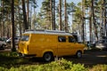 Leningrad Region, Russia - June 2022. Camping for cars in nature in a pine forest. The old stylish yellow shiny retro