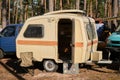 Leningrad Region, Russia - June 2022. Small brown retro trailer for whole family camping in woods. Festival of mobile