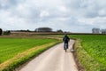 Lennik, Flemish Brabant, Belgium - Man cycling through the harvested fields of the Flemish countryside