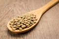 Lentil legume. Spoon and grains over wooden table.