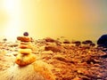 Balanced stone pyramid on sea shore, waves in background. Colorful stones Royalty Free Stock Photo