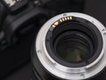 A lens and a digital camera on a black background Royalty Free Stock Photo