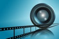 Lens & film strip on blue background Royalty Free Stock Photo