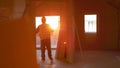 LENS FLARE: Architect walks around a house under construction at golden sunset. Royalty Free Stock Photo