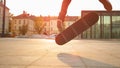 LENS FLARE: Athletic man doing a cool flip trick while skateboarding at sunset.