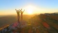 LENS FLARE: Caucasian couple celebrates reaching top of mountain at sunset.