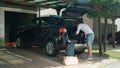 LENS FLARE: Cheerful young man packing his bags in car before going on holiday. Royalty Free Stock Photo