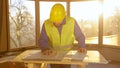 LENS FLARE: Construction site manager looks at the floor plans at sunrise. Royalty Free Stock Photo