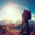 Lens flare defect. Tourist guide on trekking path with poles and backpack. Experienced hiker Royalty Free Stock Photo