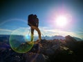 Lens flare defect. Tourist guide on trekking path with poles and backpack. Experienced hiker Royalty Free Stock Photo