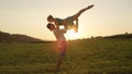 LENS FLARE: Happy man lifts blonde woman over the picturesque orange sunset. Royalty Free Stock Photo