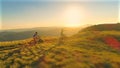 LENS FLARE: Man points where the active young couple will bike at sunrise. Royalty Free Stock Photo