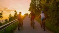 LENS FLARE: Travelers explore the rural landscape on electric bikes at sunrise. Royalty Free Stock Photo