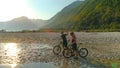 LENS FLARE: Two mountain bikers high five after a fun ride in Soca river valley. Royalty Free Stock Photo