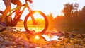 LENS FLARE: Unrecognizable cross country cyclist splashes the river water.