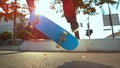 LENS FLARE: Unrecognizable male athlete does a fakie trick with his skateboard. Royalty Free Stock Photo