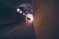 Lens-flared silhouettes of people in a circular tunnel for pedestrians and cyclists. Royalty Free Stock Photo