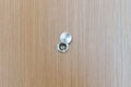 Lens peephole on wood door in apartment room. Security concept