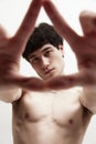 Through the lens of perception. Portrait of handsome young guy posing shirtless against white studio background. Looking Royalty Free Stock Photo