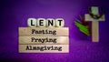 Lent Season,Holy Week and Good Friday concepts - words lent fasting praying almsgiving on wooden blocks in purple vintage Royalty Free Stock Photo