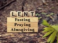 Lent Season,Holy Week and Good Friday concepts - words lent fasting praying almsgiving on wooden blocks background. Stock photo.