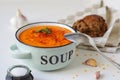 Lentil cream soup in a rustic bowl with piece of black bread on