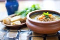 lentil soup in clay bowl with artisan bread