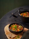 Lentil stew in bowl with vegetables, parsley chorizo spanish soup on a dark green background, copy space. Selective focus. Royalty Free Stock Photo