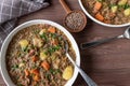 Lentil stew with potatoes, vegetables and pork meat on a plate on wooden table from above Royalty Free Stock Photo