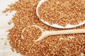 Lentil in a wooden bowl on a wooden background near the ears of wheat. wooden spoon